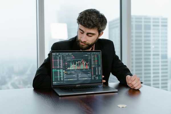 Trader presenting a crypto exchange dashboard on a laptop